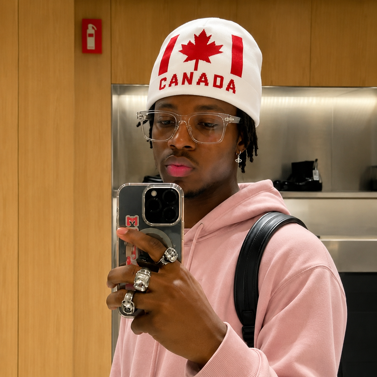 white knit beanie features a red embroidered maple leaf and the word "CANADA" in red lettering