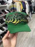 green Godspeed Neo Trucker Hat featuring oversized, colorful graffiti-style embroidery.