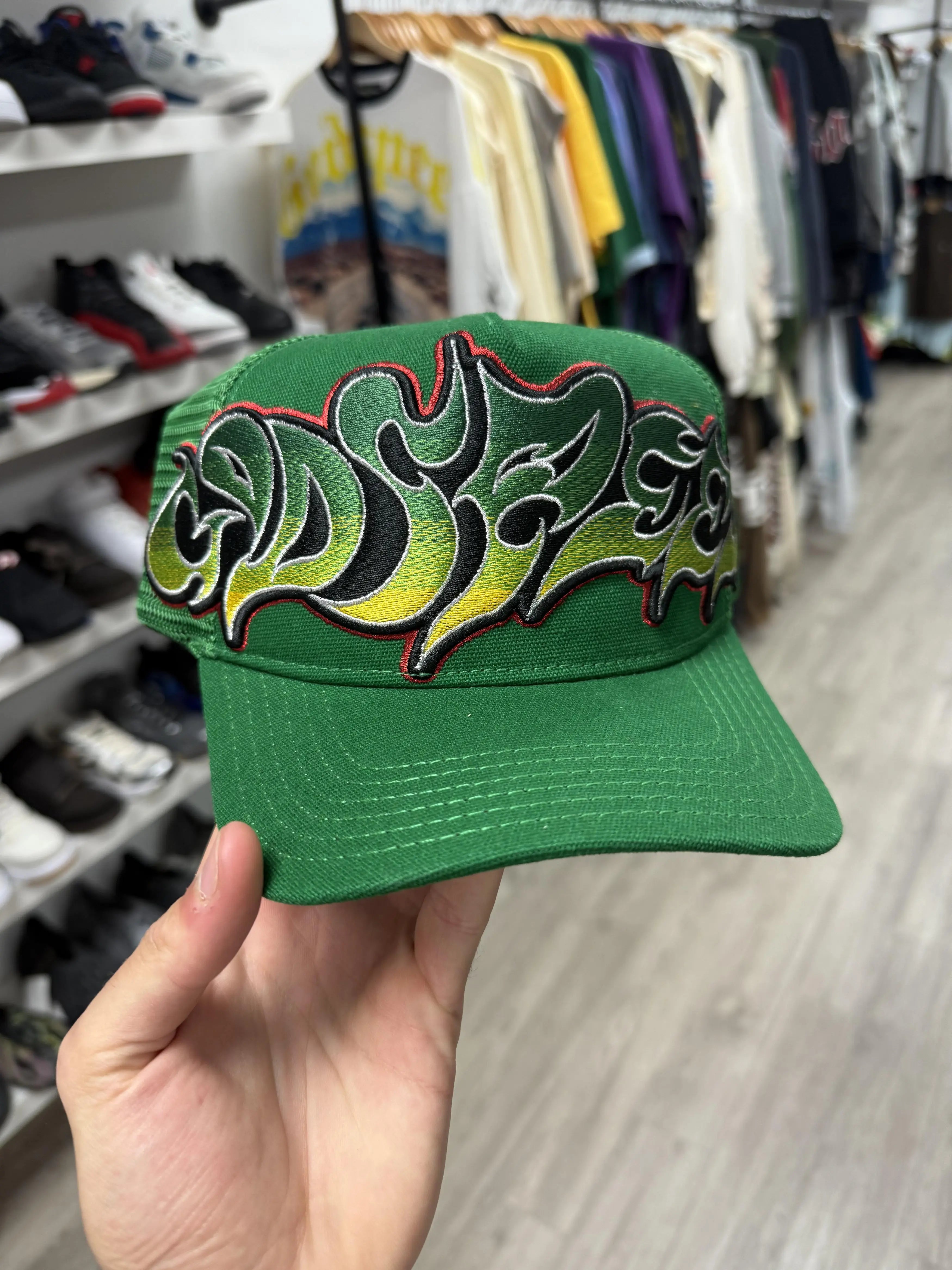 green Godspeed Neo Trucker Hat featuring oversized, colorful graffiti-style embroidery.