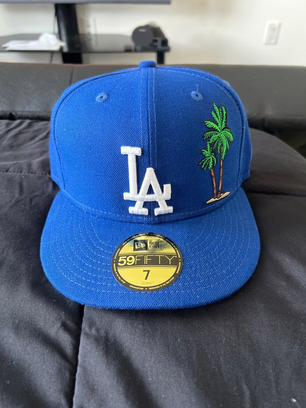 royal blue New Era 59FIFTY fitted hat features an embroidered Los Angeles Dodgers "LA" logo on the front and a palm tree icon on the side.