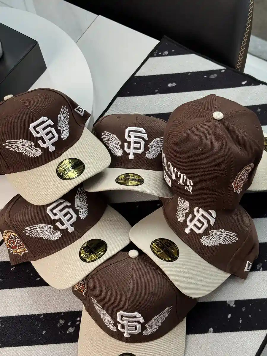 New Era San Francisco Giants "Team Wings" 59FIFTY fitted caps featuring a brown structured crown, a contrast-color brim, and embroidered wings framing the Giants logo