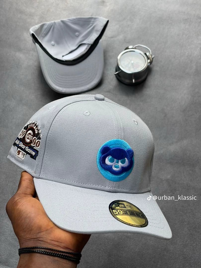 light gray Chicago Cubs New Era 59FIFTY fitted cap features a prominent blue bear logo patch on the front and a commemorative patch for a past All-Star game on the side.