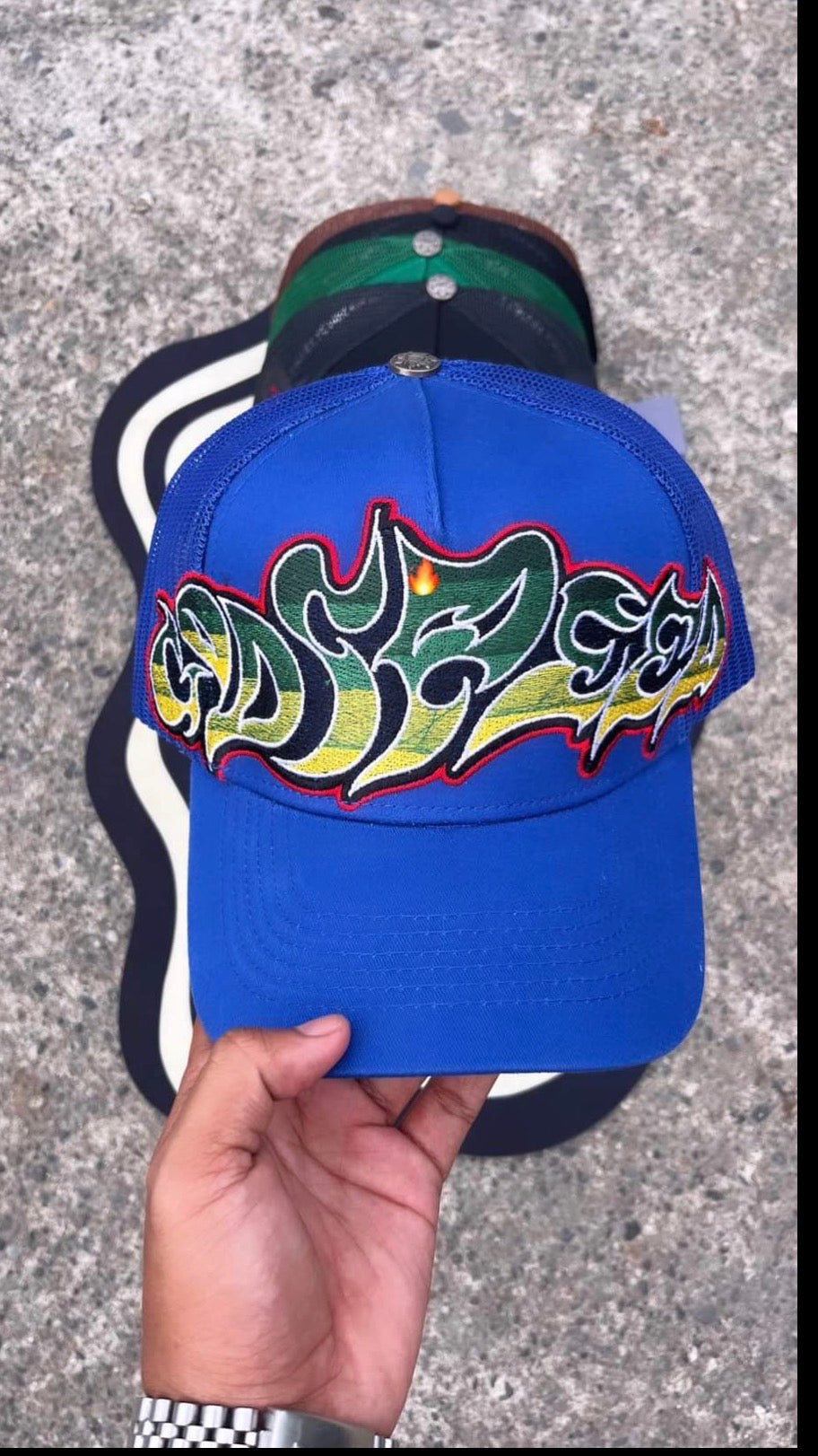 blue Godspeed Neo Trucker Hat features a prominent, multicolored embroidered logo.