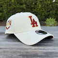 cream New Era 9FORTY A-Frame snapback features a red "LA" logo with gold outlining and a 50th Anniversary side patch