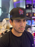 black New Era Houston Astros cap featuring a prominent blue and red flame logo embroidered on the front