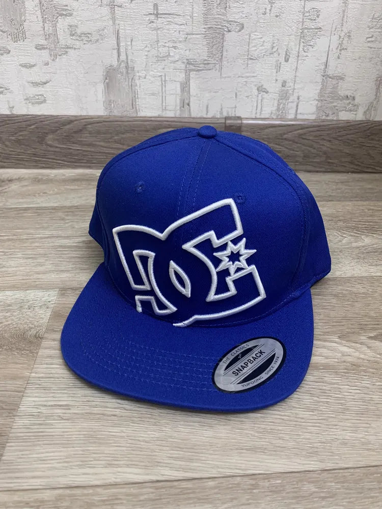 royal blue DC Shoes snapback baseball cap featuring a large, embroidered white logo on the front.